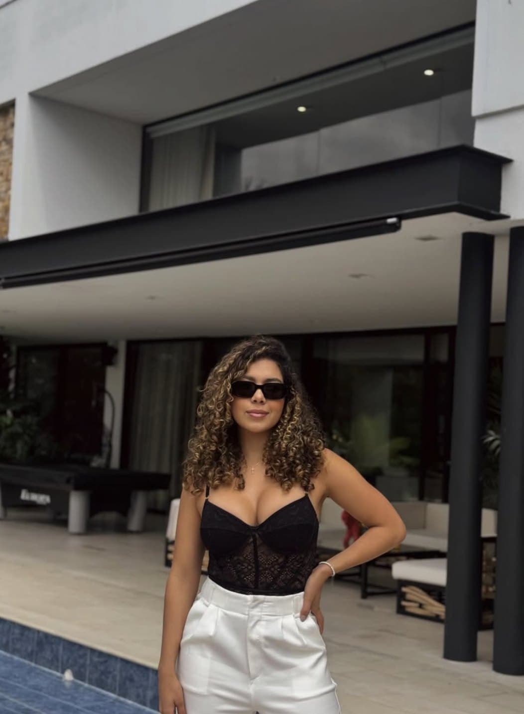 Carolina Benítez frente a una casa contemporánea con piscina